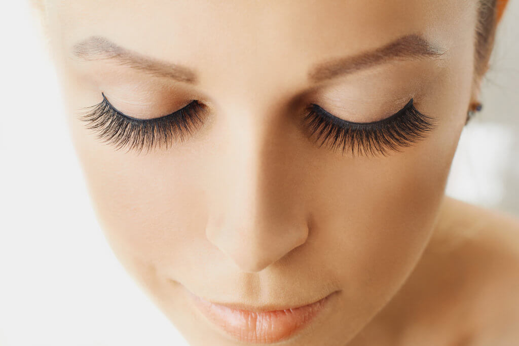 Beautiful girl with long false eyelashes and perfect skin. Eyelash extensions, cosmetology, beauty and skin care. Close up, macro